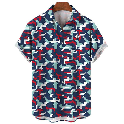 The Combat2Coffee Army Camo Shirt is a short-sleeve button-up featuring a blue, white, red, and light gray geometric camo pattern—ideal for supporting veterans and mental health awareness. Neatly displayed on a wooden hanger.