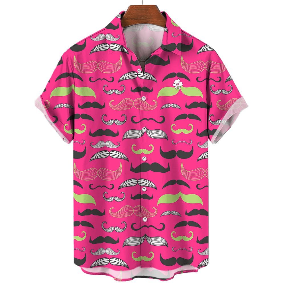 The Movember Shirt is a short-sleeve, button-up with a bright pink background and black, white, and green moustache patterns. A fun cartoon face with a moustache peeks from the pocket—ideal as a statement or Movember shirt.