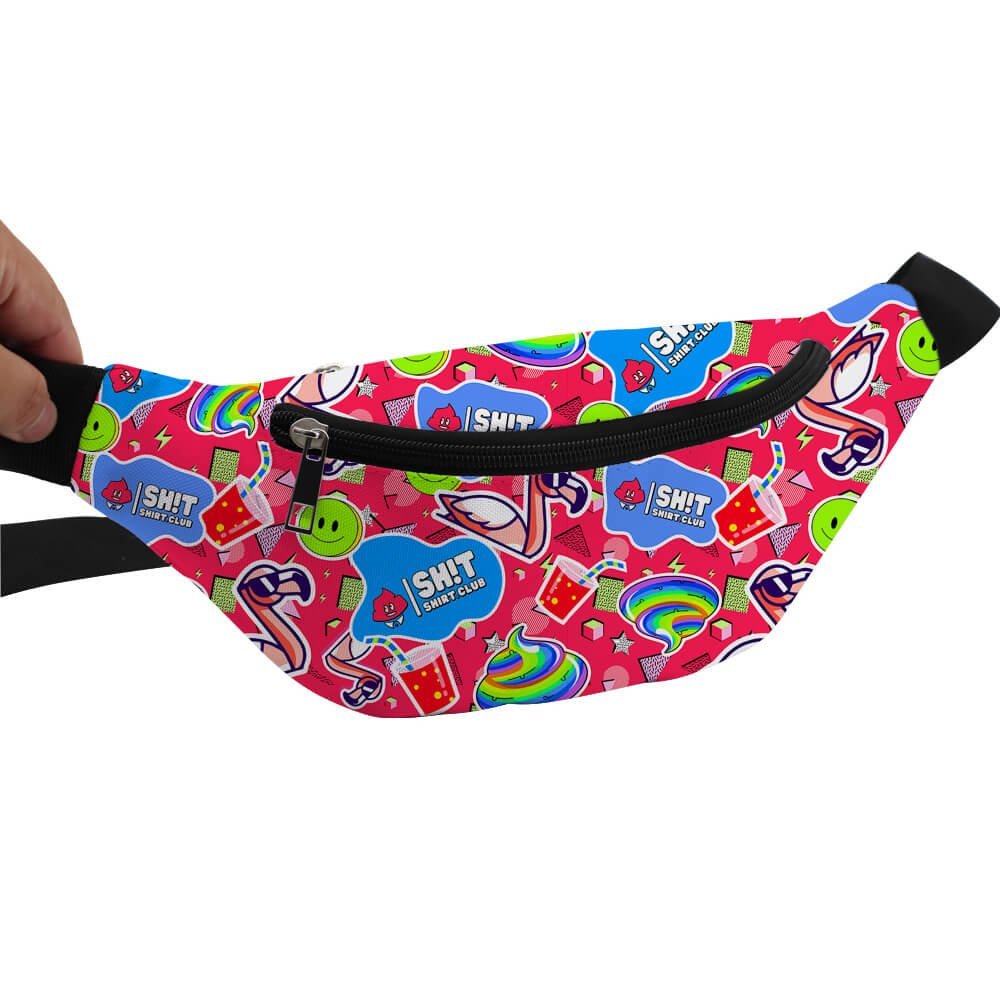 A hand holds a bright pink Badass Bum Bag, decorated with colorful stickers like smiley faces, rainbows, and SH!T SHIT CLUB labels. This playful bag features a black zipper and black straps for easy, hands-free wear.