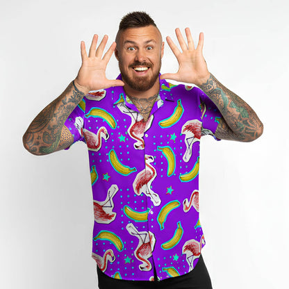 Man wearing a colourful shirt with flamingo and banana pattern on a white background