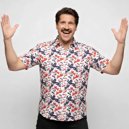 Man wearing a colorful patterned England shirt with arms raised on a light gray background