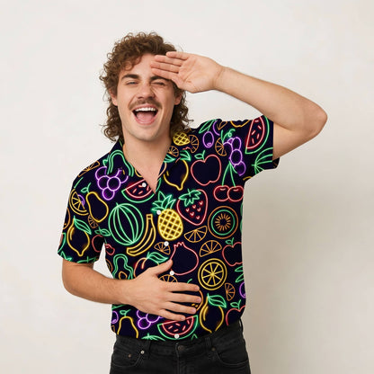 Man wearing a colourful neon fruit pattern shirt on a plain background