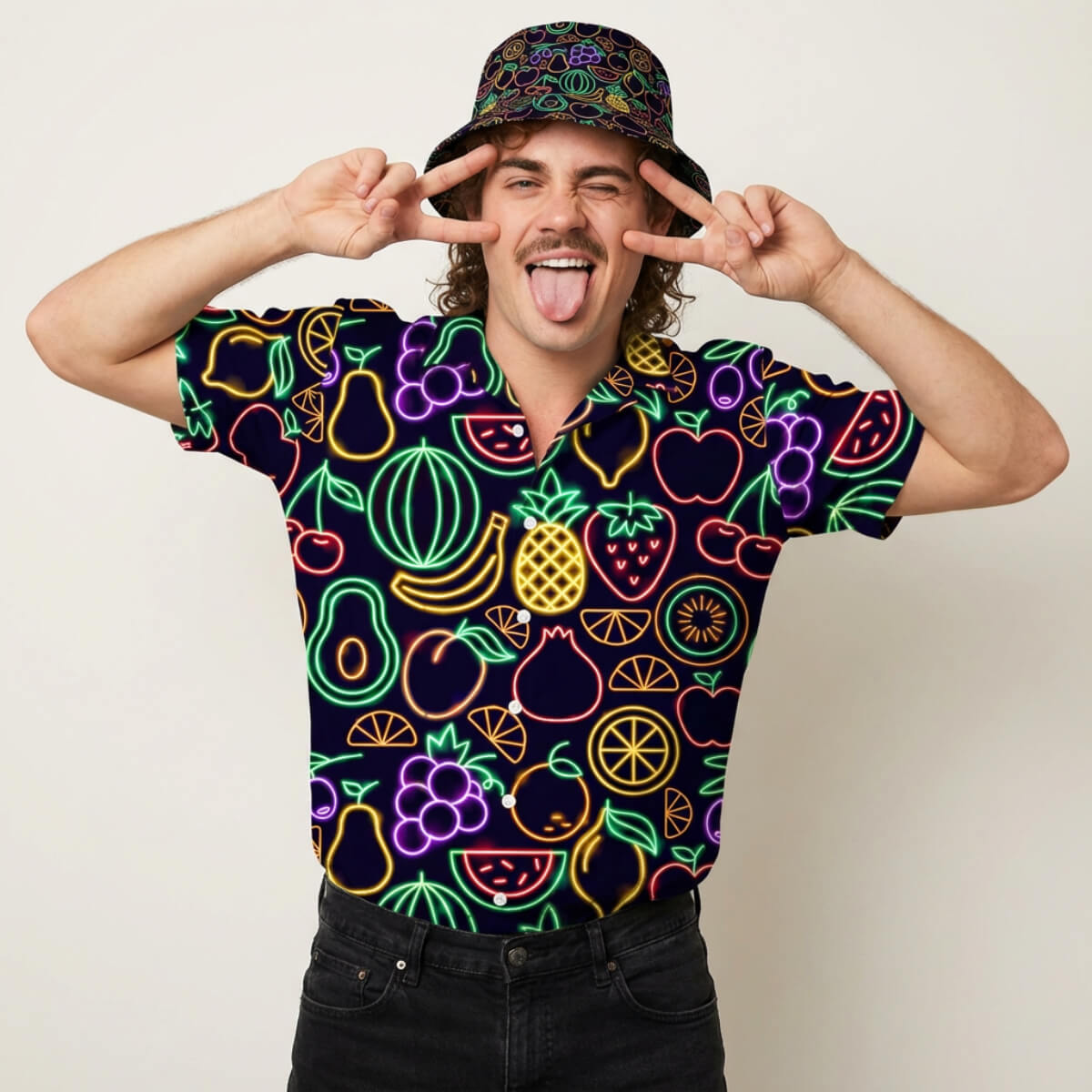 Person wearing a colourful shirt with fruit patterns and a matching hat, making peace signs.