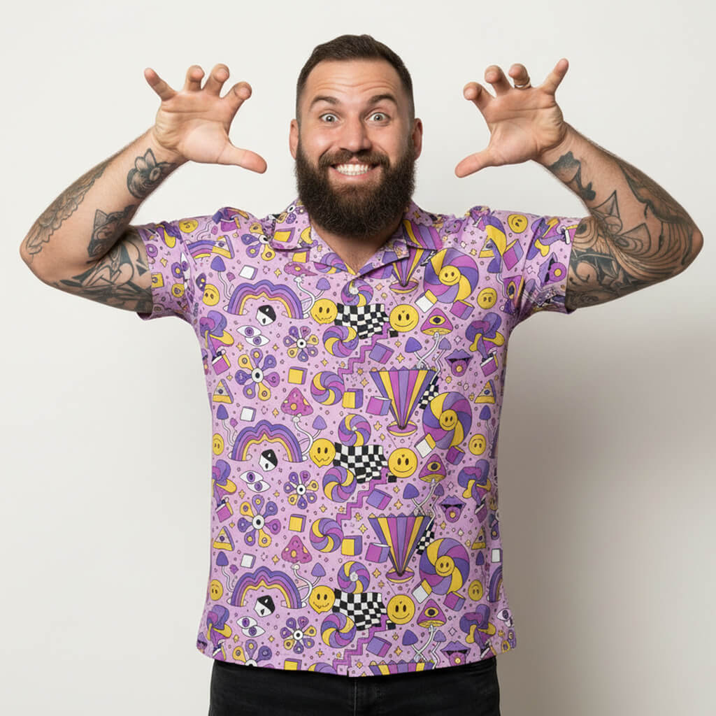 Man wearing a purple patterned shirt with arms outstretched on a plain background