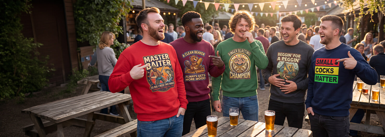 Group of men standing around a wooden table with drinks, wearing colorful funny sweatshirts in a beer garden.