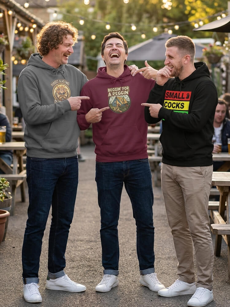 Three men laughing together in a beer garden, wearing funny hoodies with rude graphics.