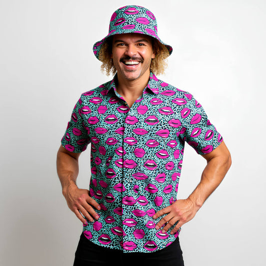 Man wearing a colourful shirt and bucket hat with lip pattern on a plain background