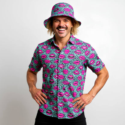 Man wearing a colourful shirt and bucket hat with lip pattern on a plain background