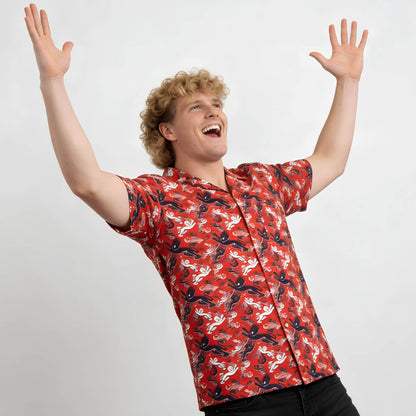 Person wearing a red patterned England shirt with arms raised on a white background