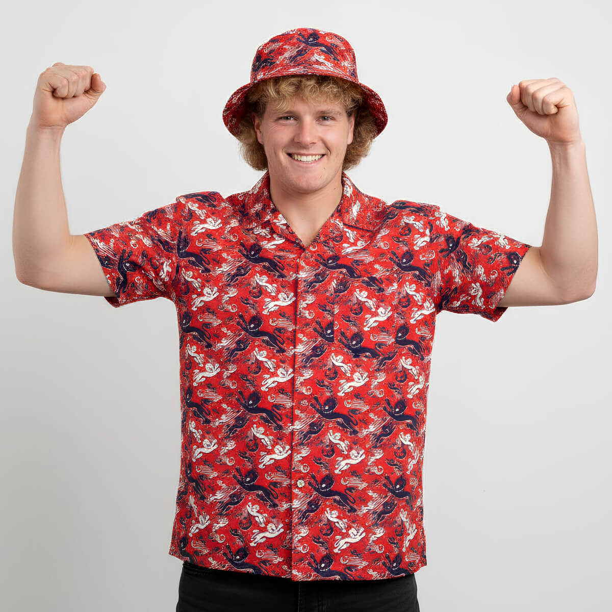Person wearing a red patterned England shirt and bucket hat on a plain background