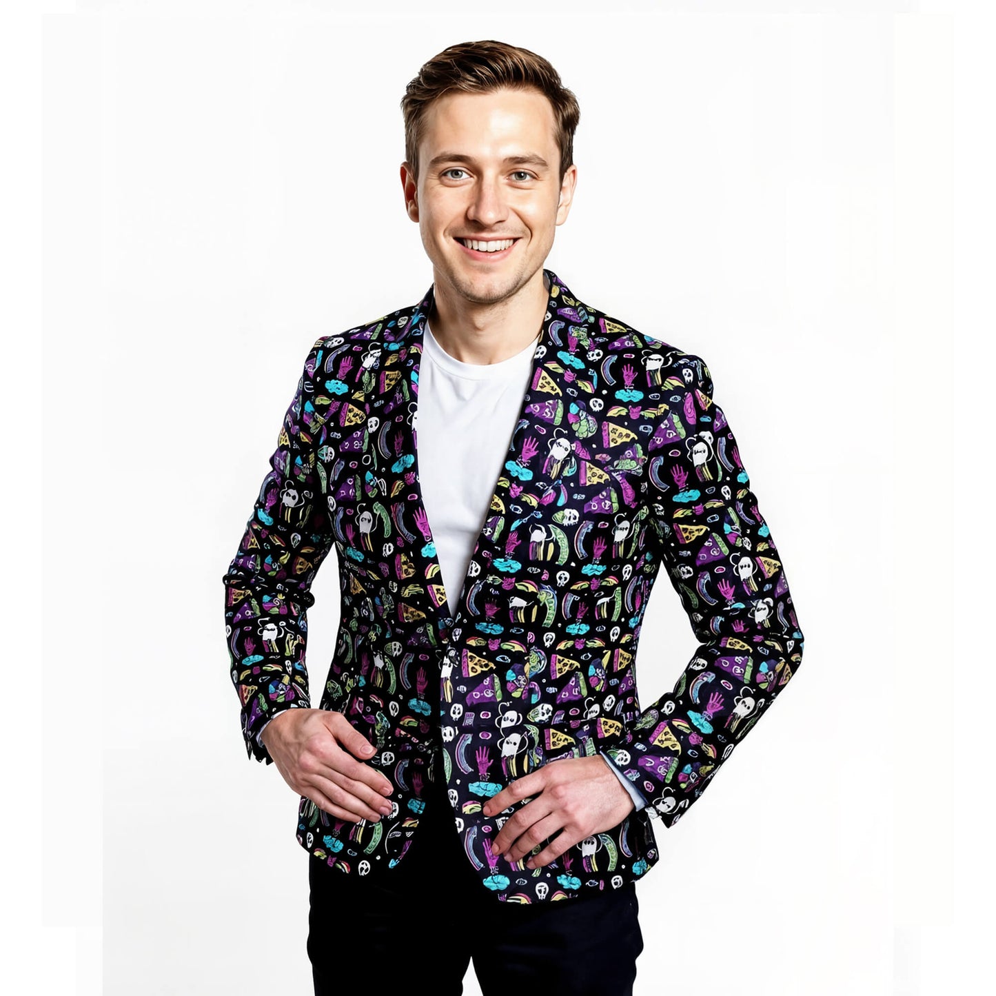 A smiling man poses against a white background, wearing a white T-shirt and the Shroom Blazer—an eye-catching suit jacket featuring playful, cartoon-style graphics in vibrant colors. His hands rest casually near his waist.