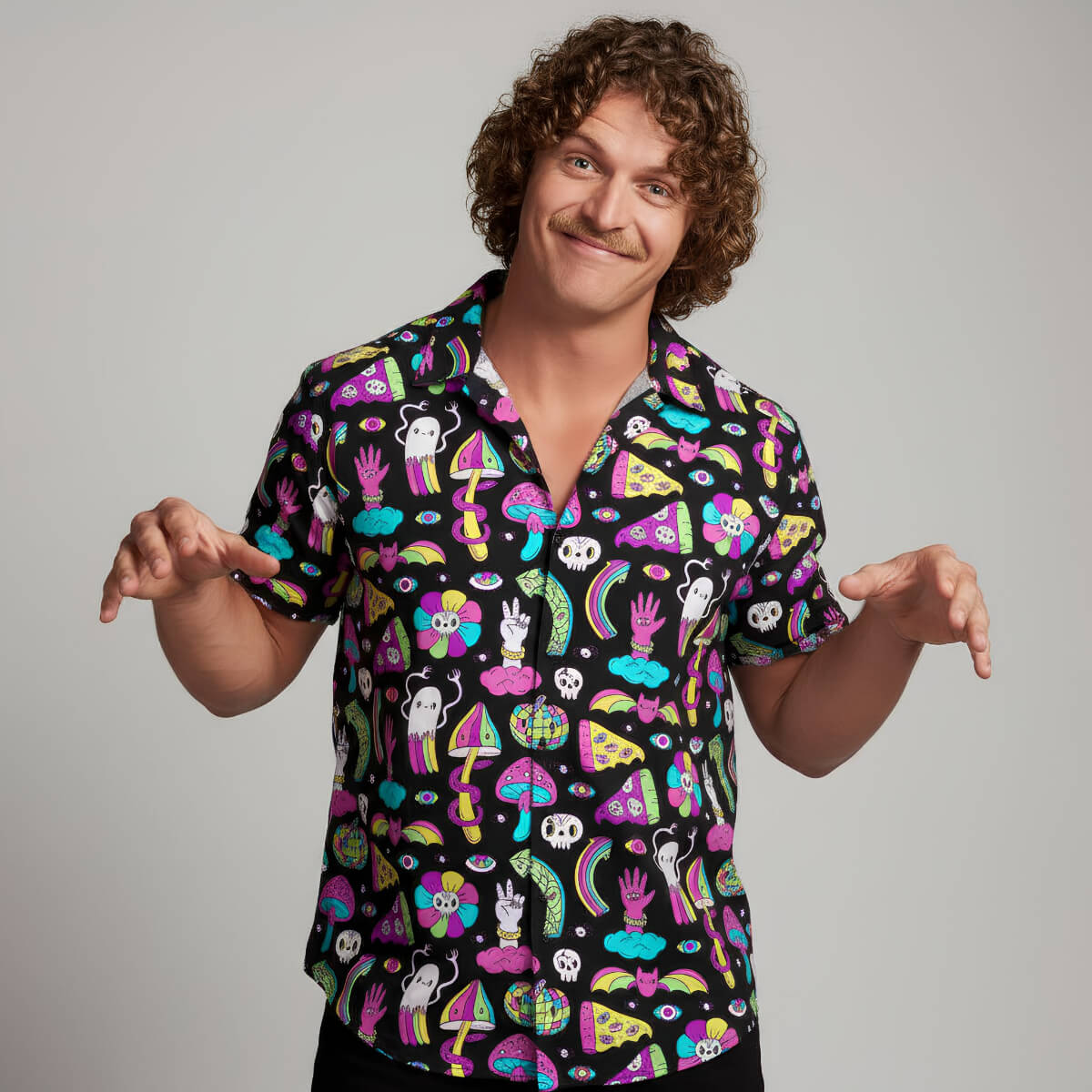 Person wearing a colourful patterned shirt on a plain background