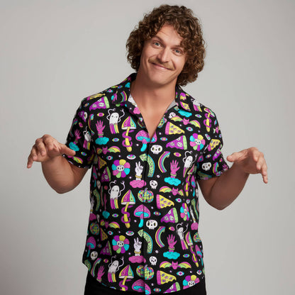 Person wearing a colourful patterned shirt on a plain background