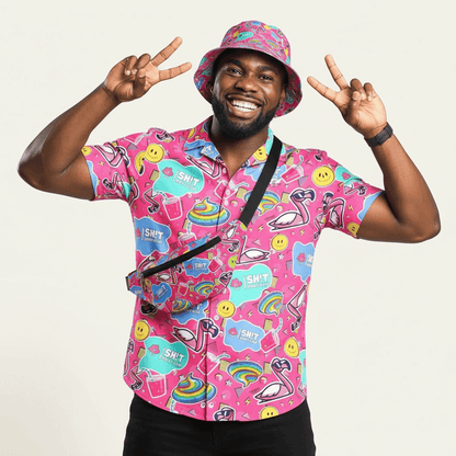 Person wearing a colourful pink shirt with various designs and a matching bucket hat on a plain background