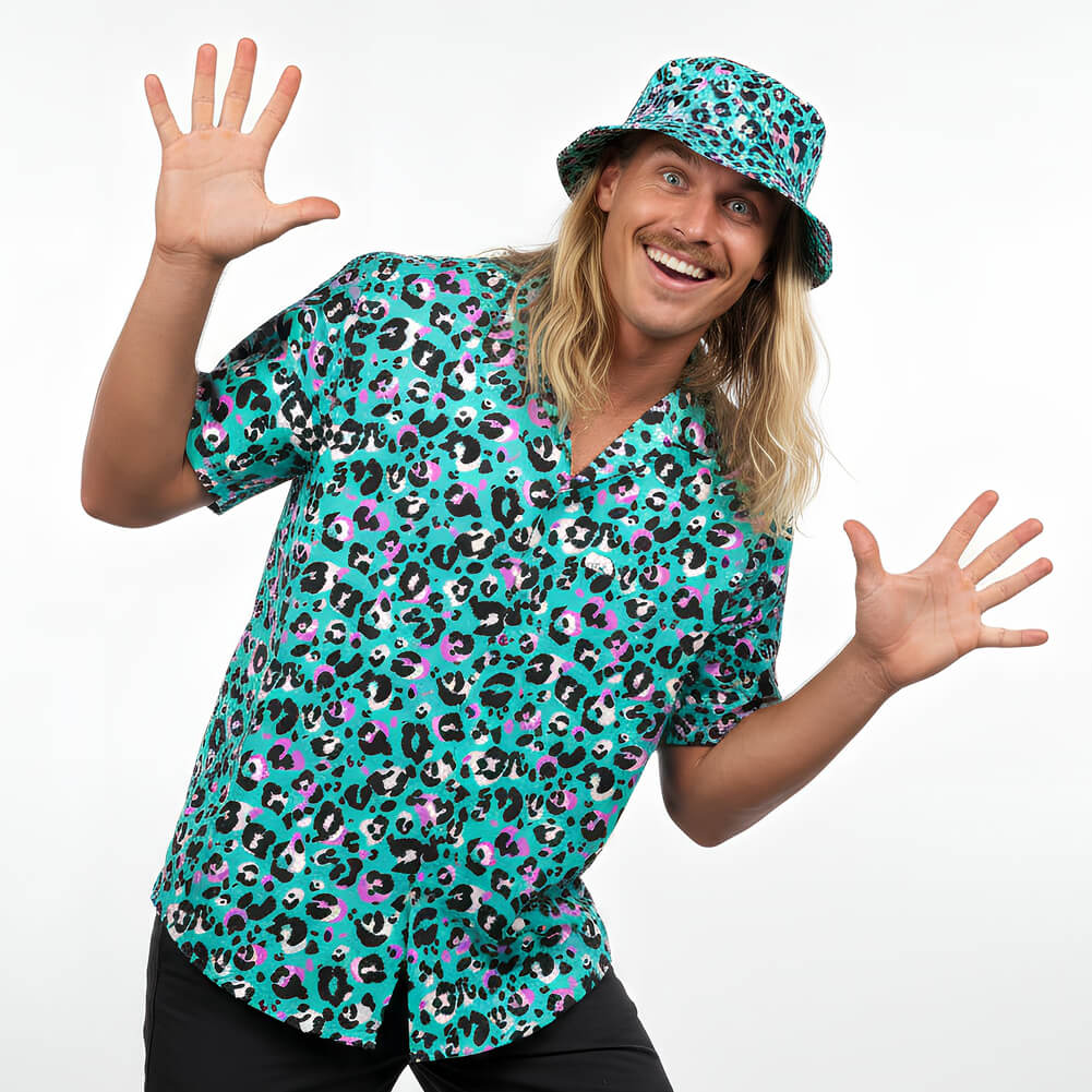 Person wearing a turquoise shirt with colorful leopard print and matching hat on a white background