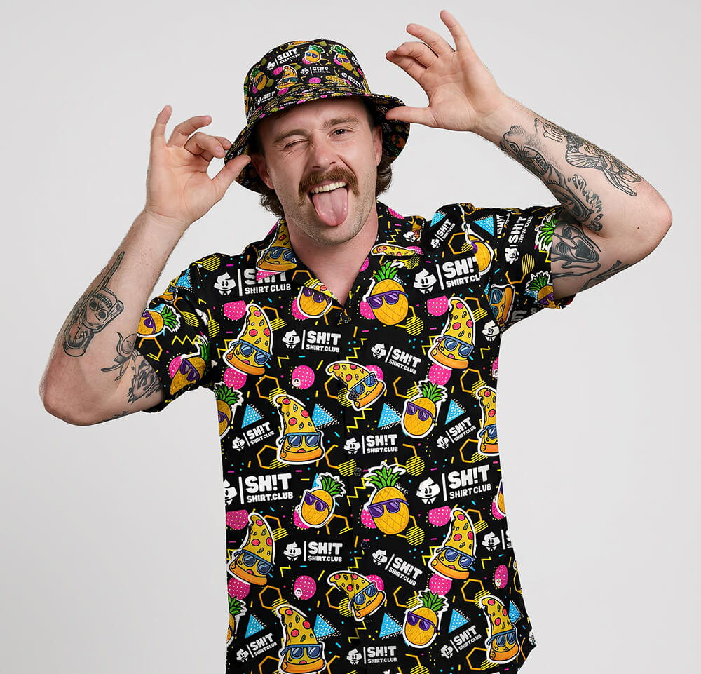 Person wearing a colourful patterned shirt and hat with various designs on a plain background