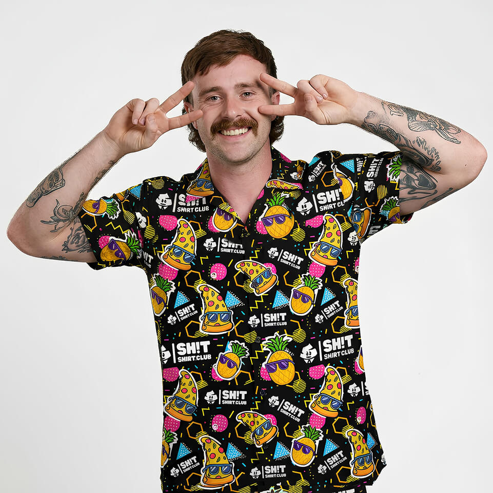 A person wearing a colourful, patterned shirt with various designs and text.
