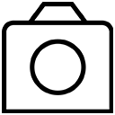 A simple black and white line drawing of a camera with a large circular lens in the center and a rectangular body.
